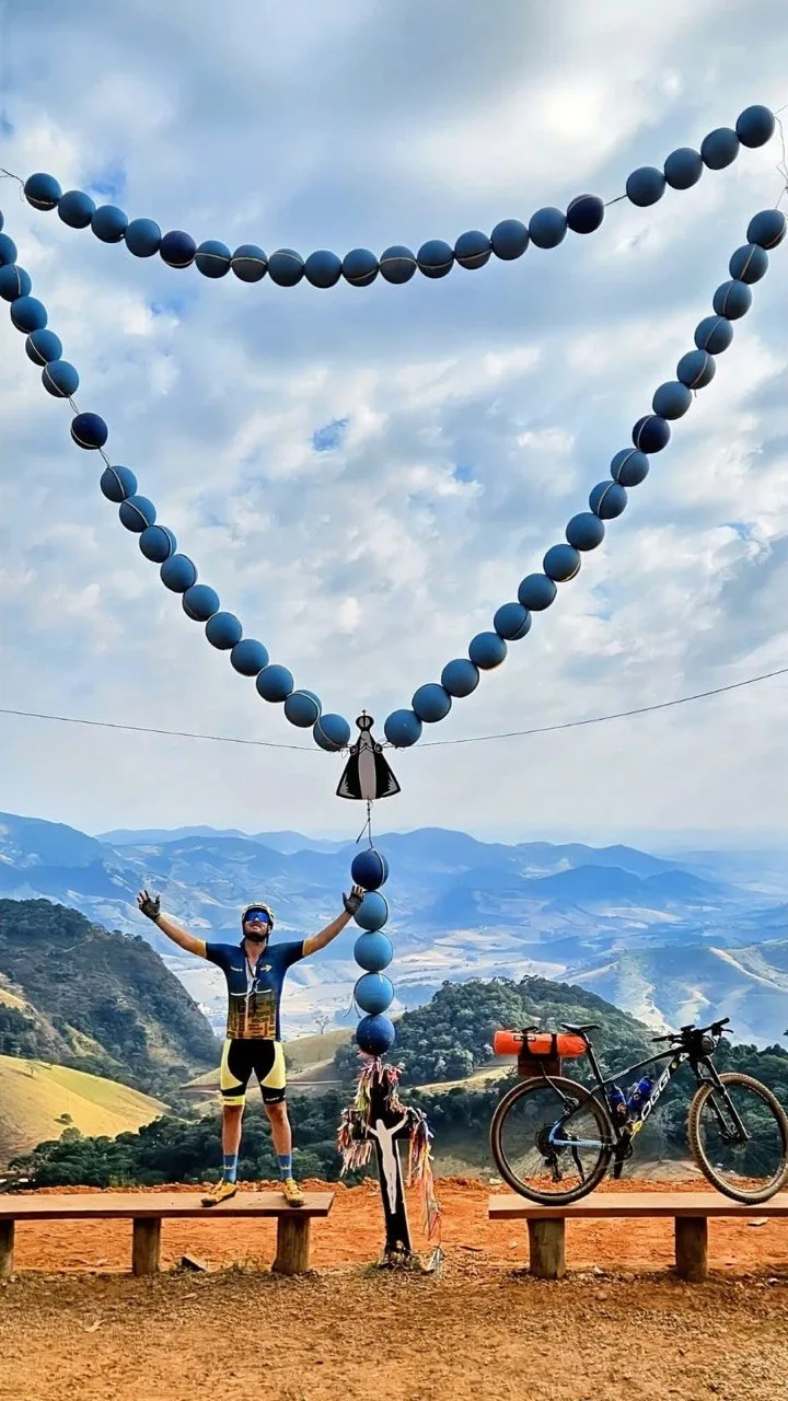 Clodoaldo no topo da serra com o terço gigante ao fundo